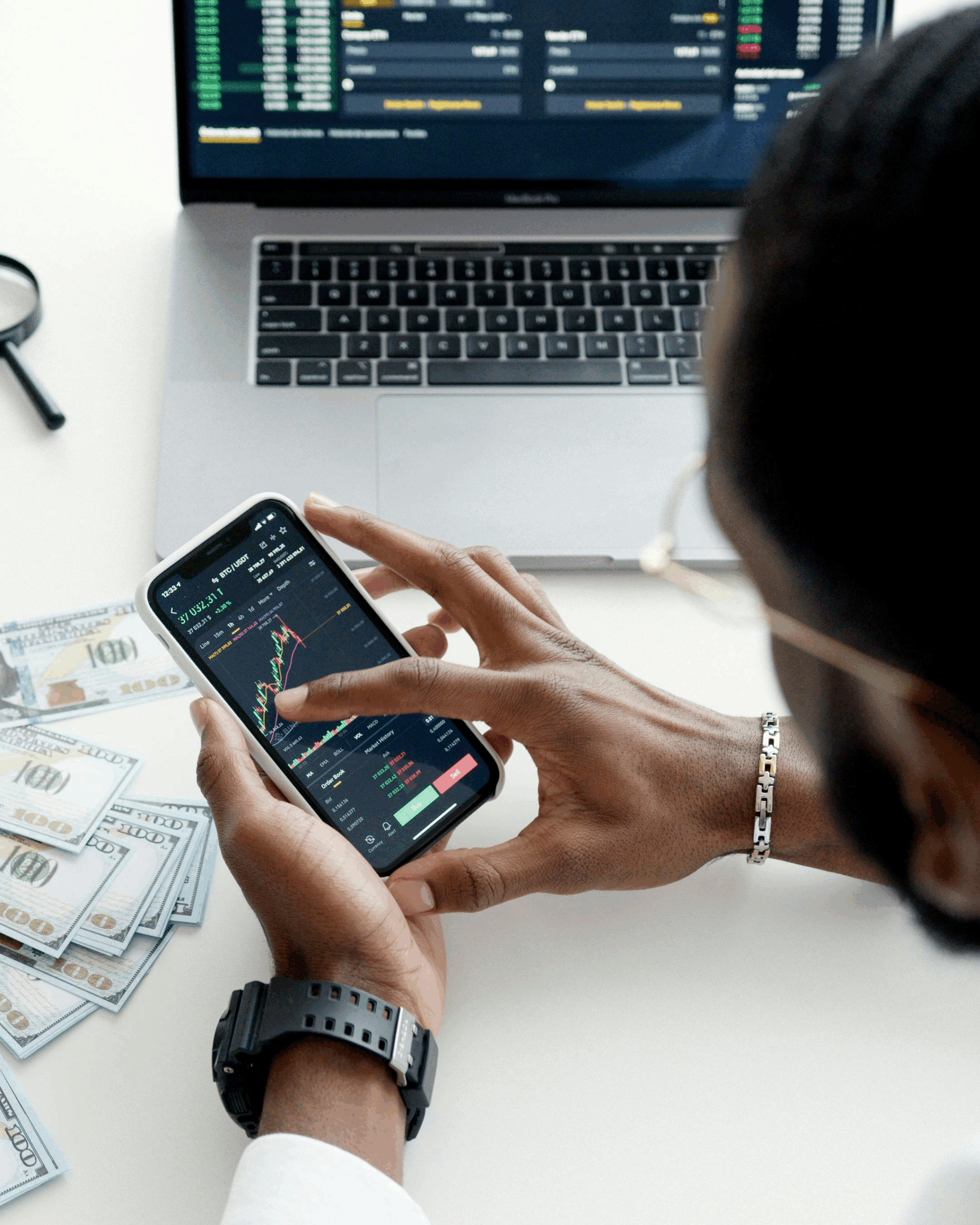 man holding phone with graphs on it